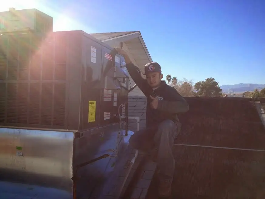 HVAC technician performing Air Duct Cleaning on a rooftop unit in York